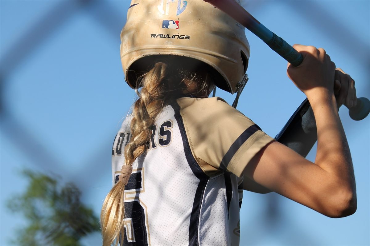 A Fury player waiting in the batter's box, bat cocked over her shoulder
