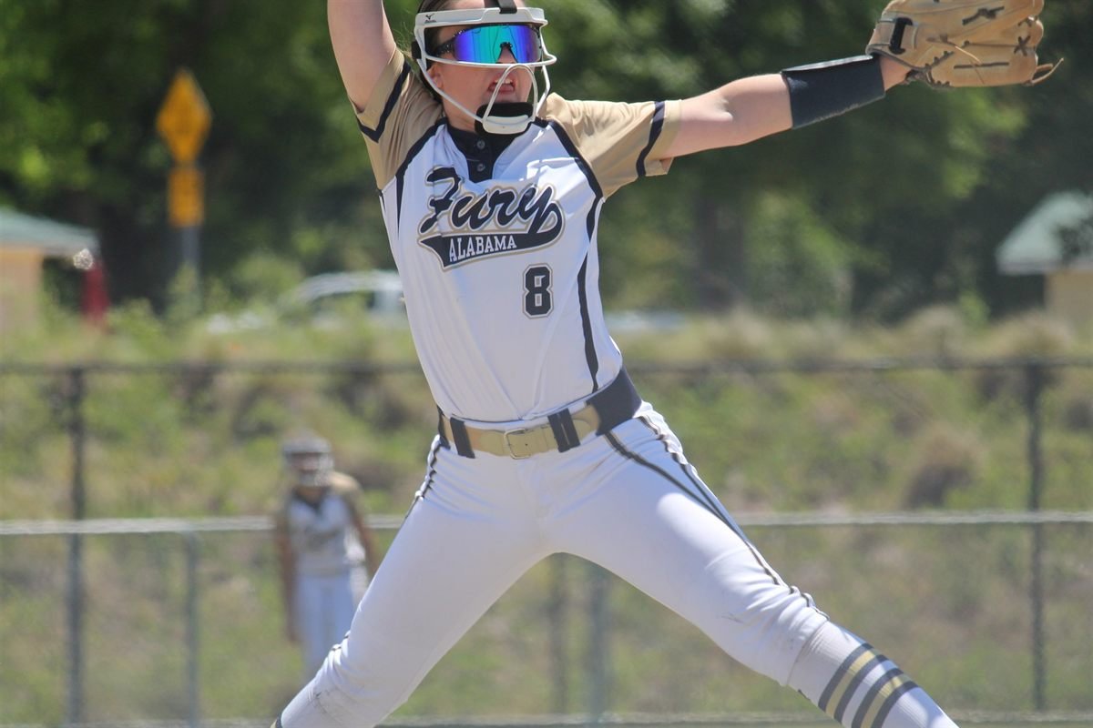 A Fury pitcher at full extension in her wind-up against a blue sky
