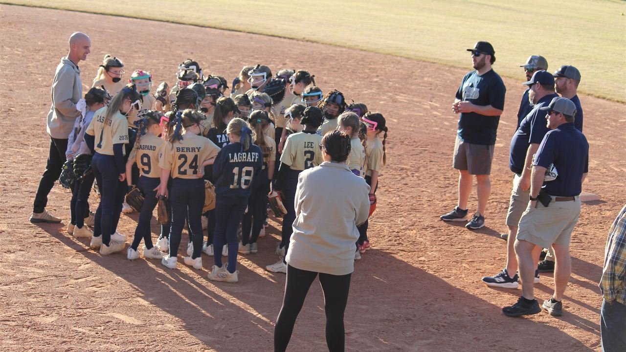 A large group of Fury players gathered around their coaches on the infield