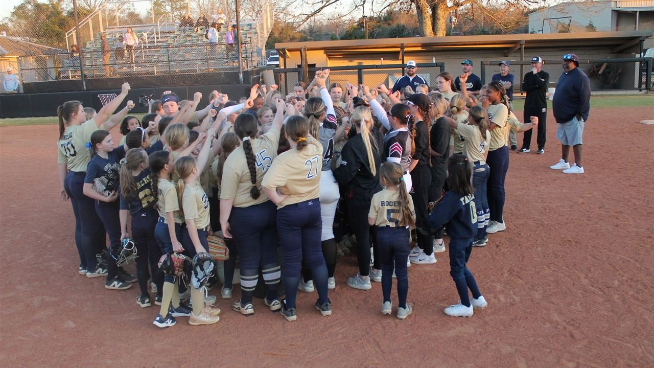 Fury players and coaches with hands raised together in a huddle at golden hour