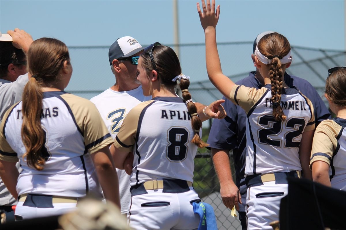 A Fury coach and players celebrating together along the fence line